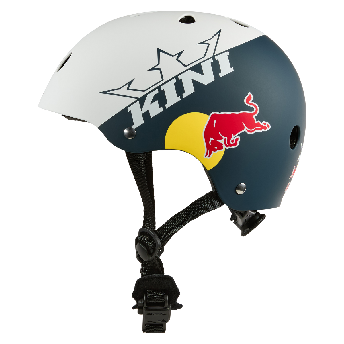 Der Kini Red Bull BB Helm Kinder 1.0 hat ein weißes und dunkelblaues Design, ein Red Bull-Logo, einen auffälligen "KINI"-Schriftzug, einen schwarzen, verstellbaren Riemen und einen sicheren Fidlock-Magnetverschluss für eine einfache Befestigung.