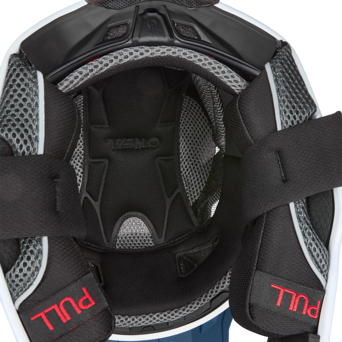 Nahaufnahme des KINI RED BULL DHC Air-Liner & Cheek Pads von Kini Red Bull mit Netz- und Schaumstofffutter, Belüftungslöchern und schwarzen Riemen mit "PULL" in roter Schrift im Inneren des Schutzhelms.