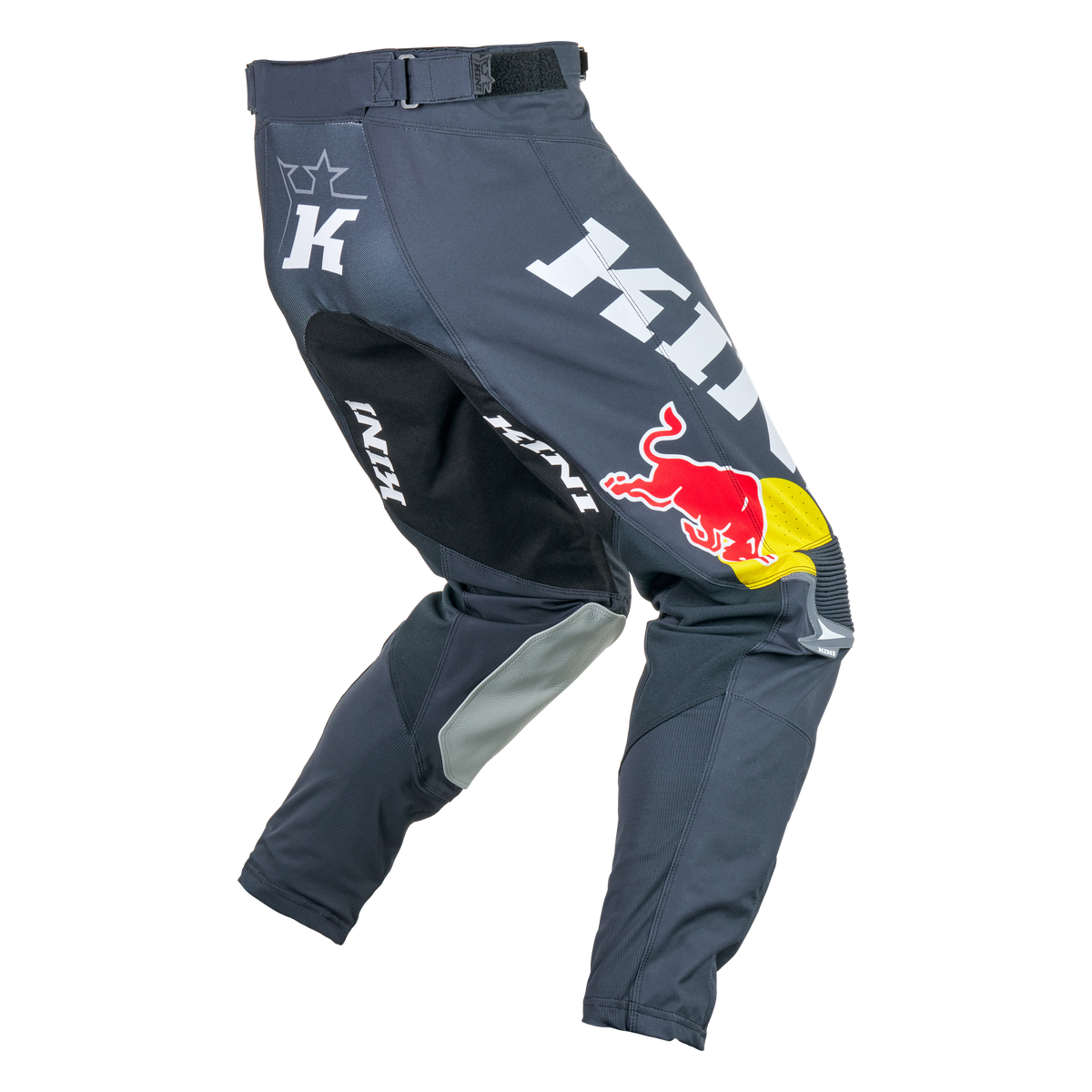 Die KINI RED BULL MXC Hose 1.0 Motocross-Hose von Kini Red Bull besteht aus dunkelgrauem Stoff mit schwarzen, grauen und weißen Akzenten sowie auffälligen weißen und roten Sponsorenlogos, darunter ein großes Red Bull-Logo auf dem rechten Oberschenkel.
