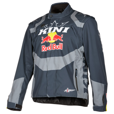 Die Kini Red Bull EXC Jacke 1.0 hat ein auffälliges Kini- und Red Bull-Branding mit Logo auf der Brust, Reißverschlusstaschen und kantige Akzente an den Schultern und Ärmeln in Dunkel- und Hellgrau.