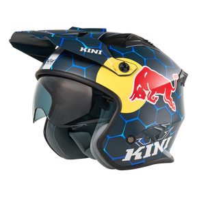 Seitenansicht des KINI RED BULL XDR 1.0 Helm von Mission Kini, ein blauer Motocross-Helm mit sechseckigem Muster, Red Bull-Logo, getöntem Visier, Sonnenschirm und "KINI"-Branding.