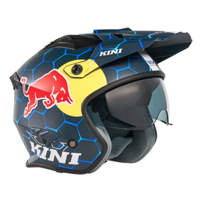 Der Mission Kini KINI RED BULL XDR 1.0 Helm ist ein blau-schwarzer Motorradhelm mit sechseckigen Mustern, Red Bull- und KINI-Logos, gelbem Hintergrund hinter der Red Bull-Grafik, getöntem Visier und eckigen Kinn-/Oberbelüftungsöffnungen.