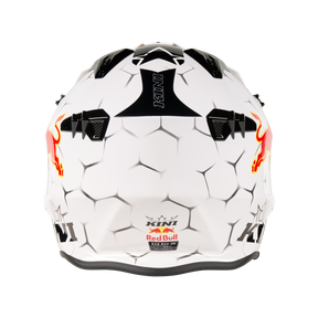 Der Mission Kini KINI RED BULL XDR 1.0 Helm ist ein weißer Sporthelm mit sechseckigem Muster, schwarzen Akzenten, roter Bullengrafik an den Seiten und "KINI"-Schriftzug auf der Ober- und Unterseite.